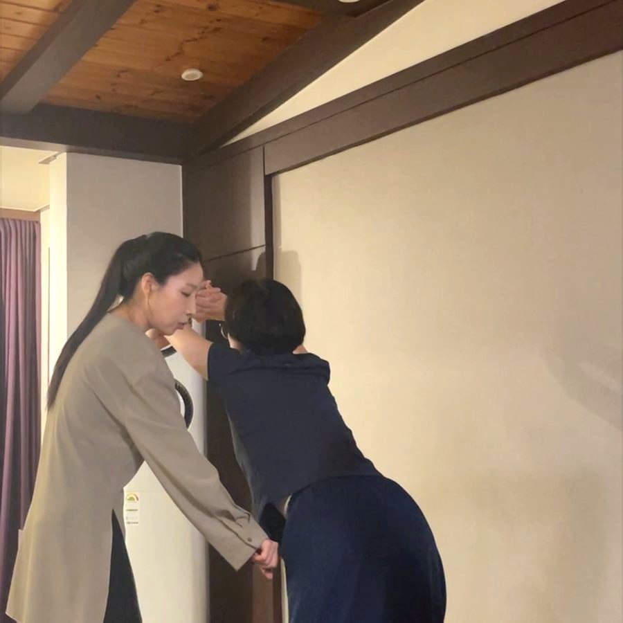 지도자가 회원의 자세를 직접 잡아주는 모습